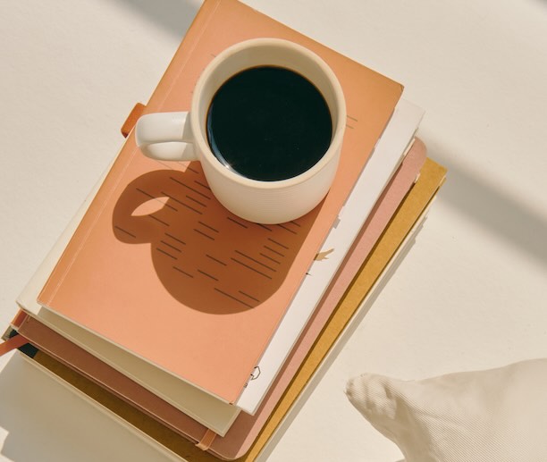 Coffee mug on a stack of notebooks